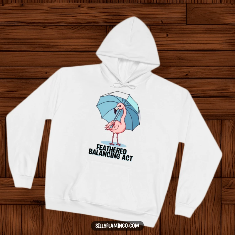 Funny kawaii flamingo hoodie showing a cute bird comically balancing an umbrella, combining comfort with adorable art.